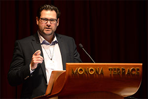 Dr. Andrew Quanbeck speaking at a podium of an event
