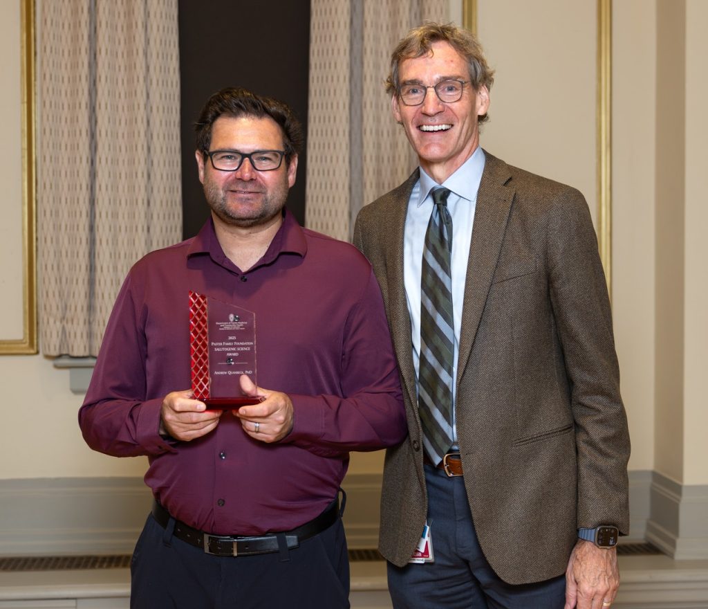 Dr. Andrew Quanbeck holding an award standing next to Dr. Dave Rakel